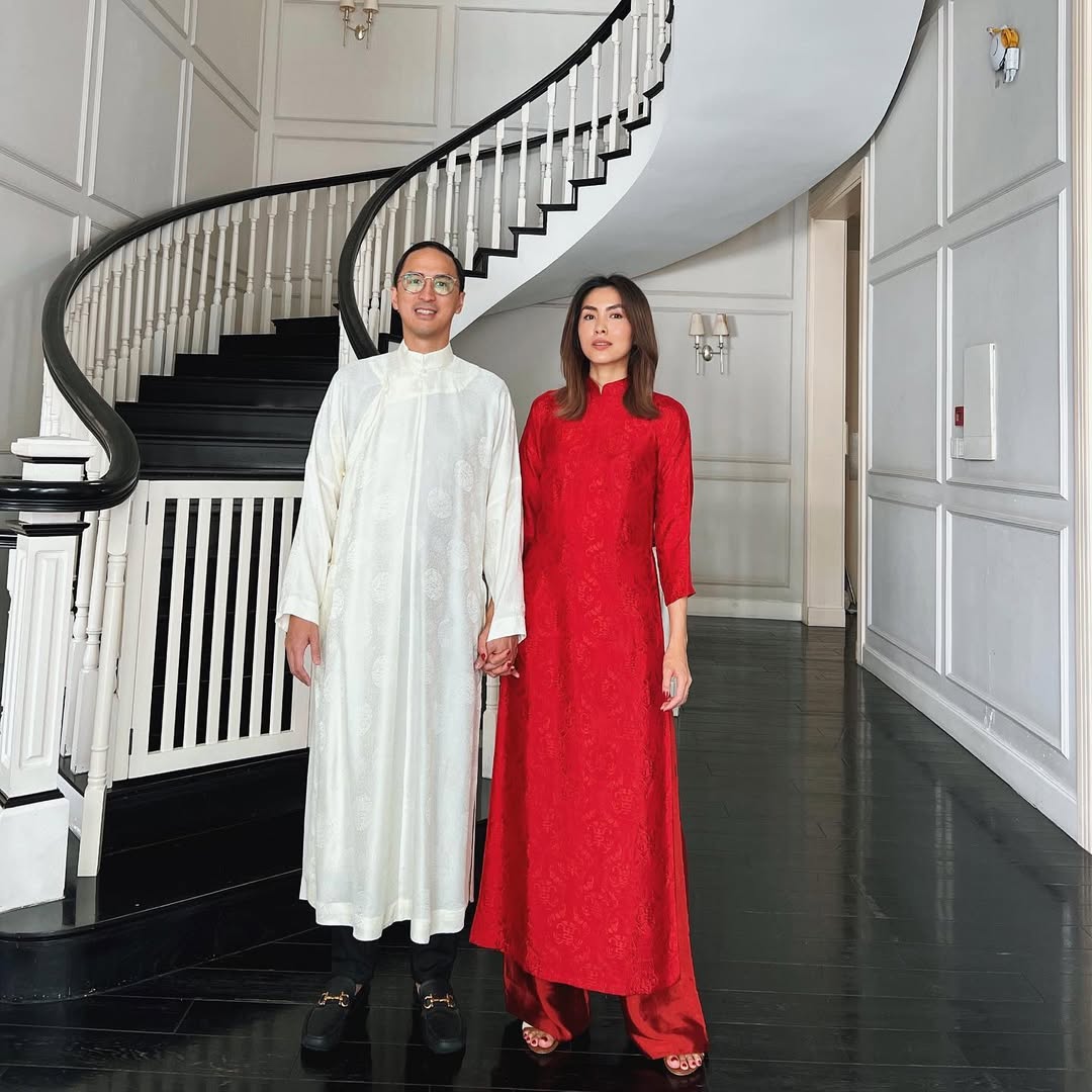 Cứ mỗi ngày mùng 1 Tết Nguyên Đán, vợ chồng Tăng Thanh Hà - Louis Nguyễn lại có một bức ảnh chụp ở chiếc cầu thang xoắn ốc quen thuộc trong biệt thự của cặp đôi. Cả hai đều diện áo dài lụa phom dáng thoải mái.