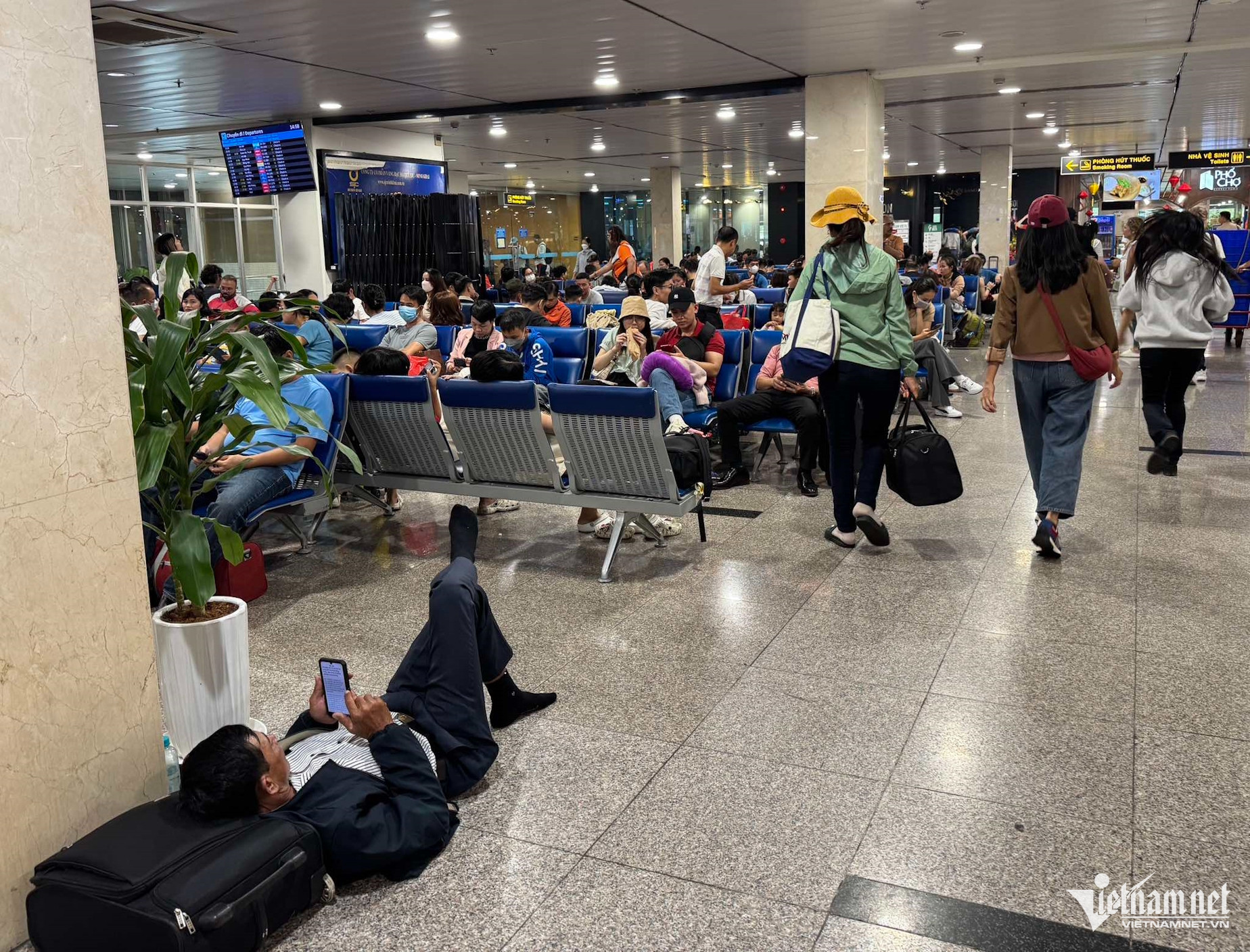 Nhiều khách mệt mỏi nằm giữa sảnh nhà ga do chuyến bay bị delay quá lâu. Ảnh: L.Mỹ.