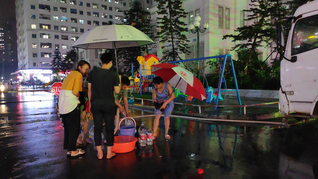 Chùm ảnh: Người dân đội mưa đi lấy nước sạch cấp miễn phí tại chung cư Linh Đàm - 2 Chùm ảnh: Người dân đội mưa đi lấy nước sạch cấp miễn phí tại chung cư Linh Đàm - 2
