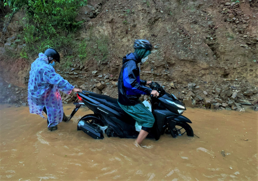 Thót tim cảnh mẹ cõng con vượt lũ trên cây cầu tạm, đoàn người vật lộn qua dòng nước cuồn cuộn - 1 Thót tim cảnh mẹ cõng con vượt lũ trên cây cầu tạm, đoàn người vật lộn qua dòng nước cuồn cuộn - 1