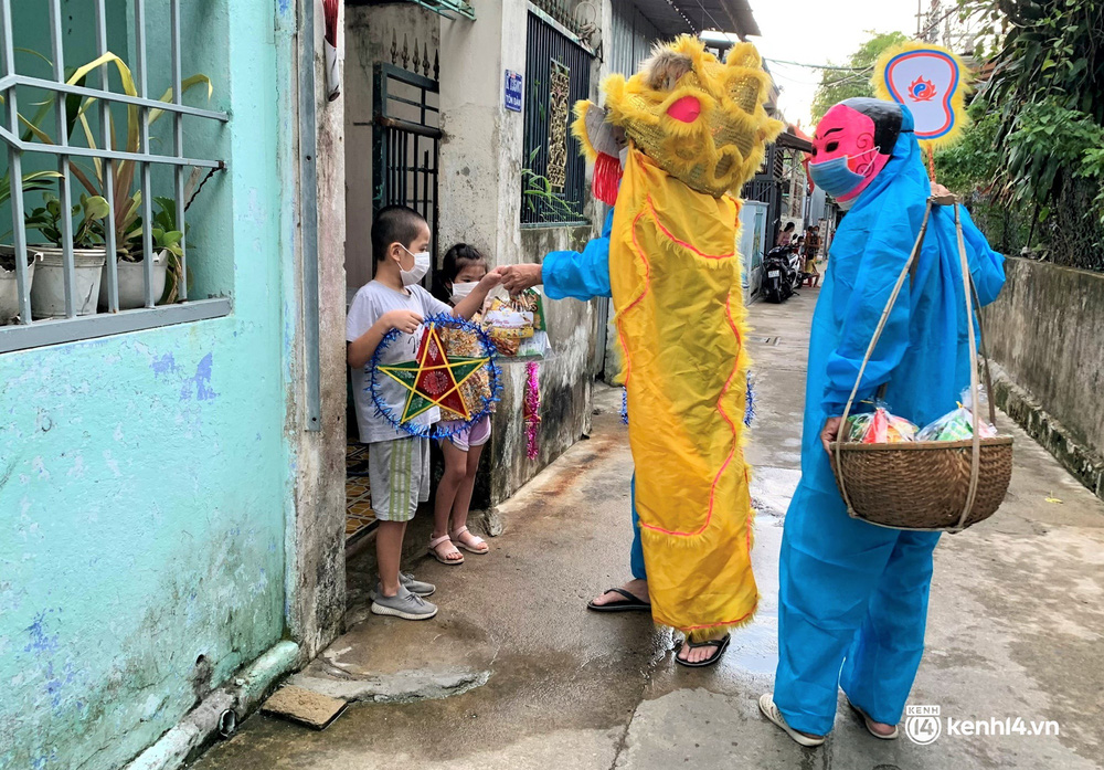 Ảnh: Tết Trung thu đặc biệt, ông địa cùng chú lân mặc đồ bảo hộ kín mít đến từng nhà tặng quà cho trẻ nhỏ Ảnh: Tết Trung thu đặc biệt, ông địa cùng chú lân mặc đồ bảo hộ kín mít đến từng nhà tặng quà cho trẻ nhỏ