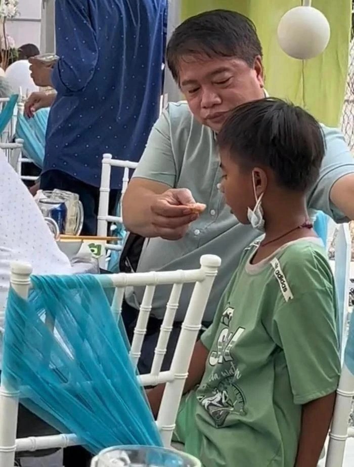 Sau khi mua vé số cho cậu bé, người đàn ông còn ân cần gắp đồ ăn cho cậu bé