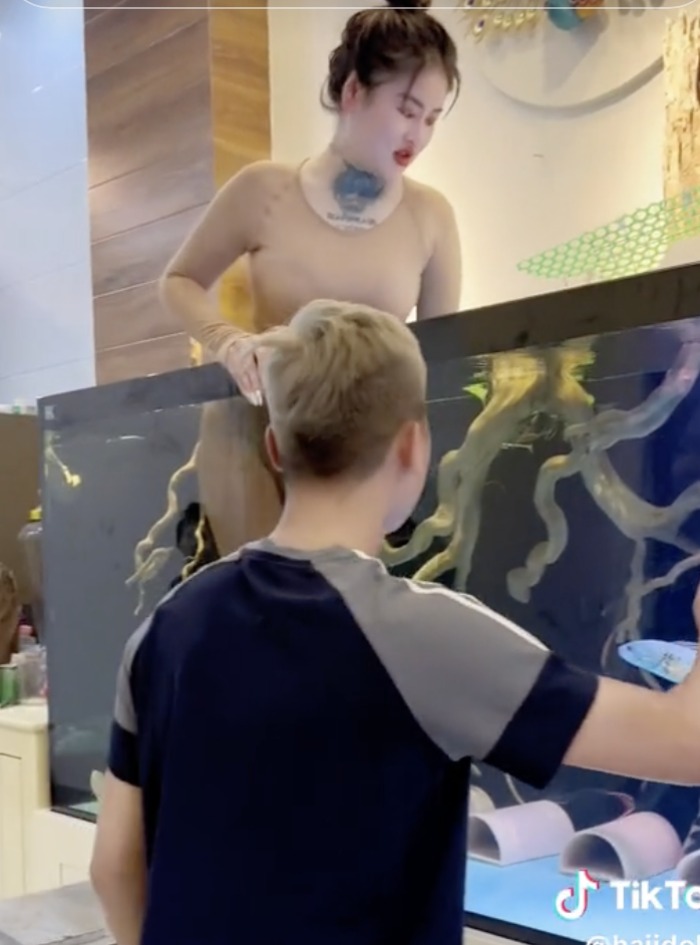 Một thanh niên giúp Ngân vào bể cá