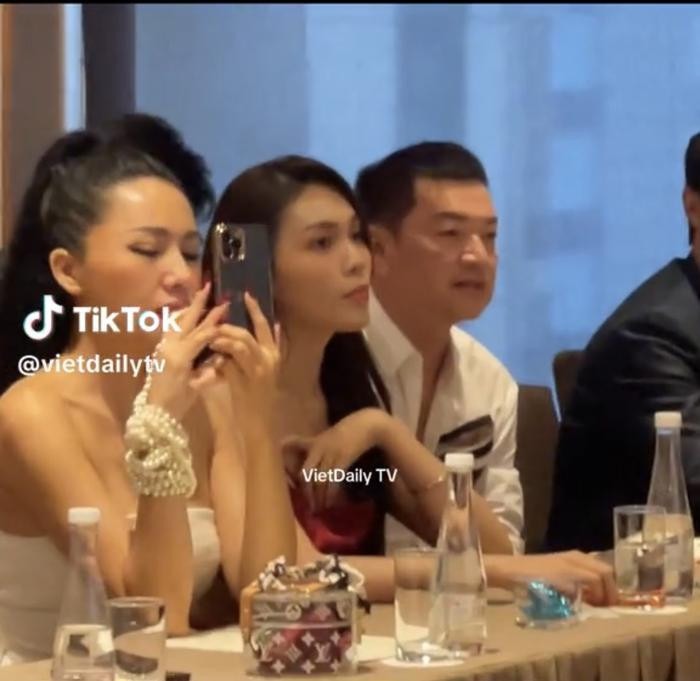 Hình ảnh nghệ sĩ Quang Minh ngồi cạnh một cô gái trẻ tại sự kiện mới đây. (Ảnh chụp màn hình TikTok VietDaily TV).