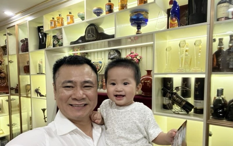 Phòng khách có tủ kệ lớn để trưng bày nhiều món đồ quý giá, trong đó các kỷ niệm chương, đồ gỗ, bình sứ và những đồ decor độc đáo.