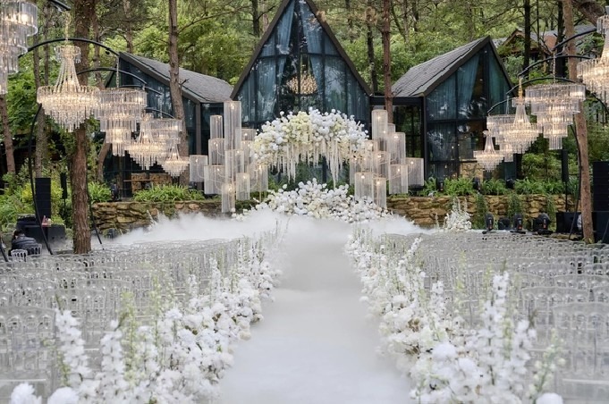 Đường hoa dẫn đến sân khấu kết hợp với khói tạo hiệu ứng mờ ảo.