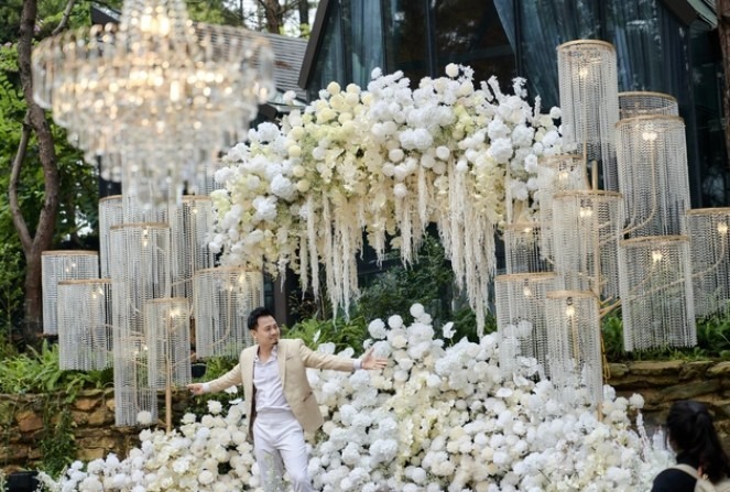 Không gian tiệc cưới trang trí ngập hoa tươi màu trắng.