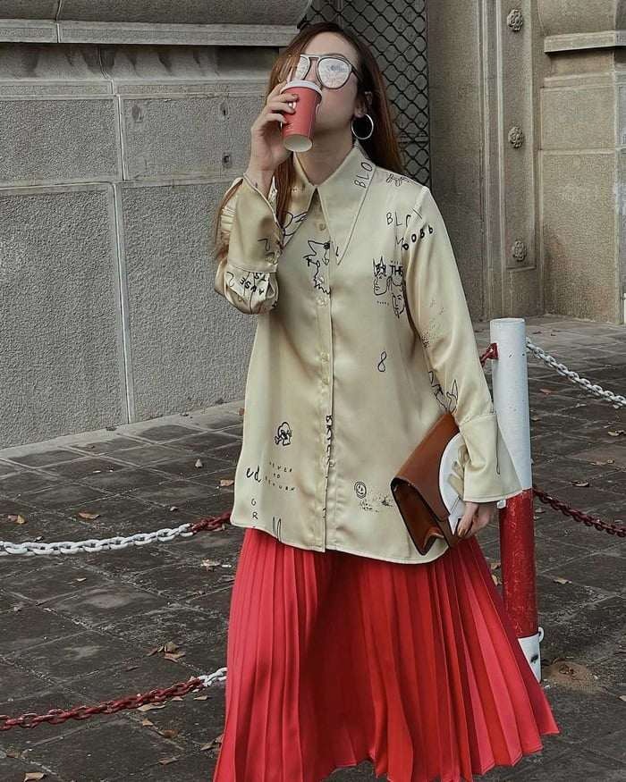 Diện váy xếp ly màu nổi bật, khá kén người mặc nhưng Yến Trang vô cùng tinh tế khi diện với áo sơ mi họa tiết khiến cô trông như fashionista đích thực.