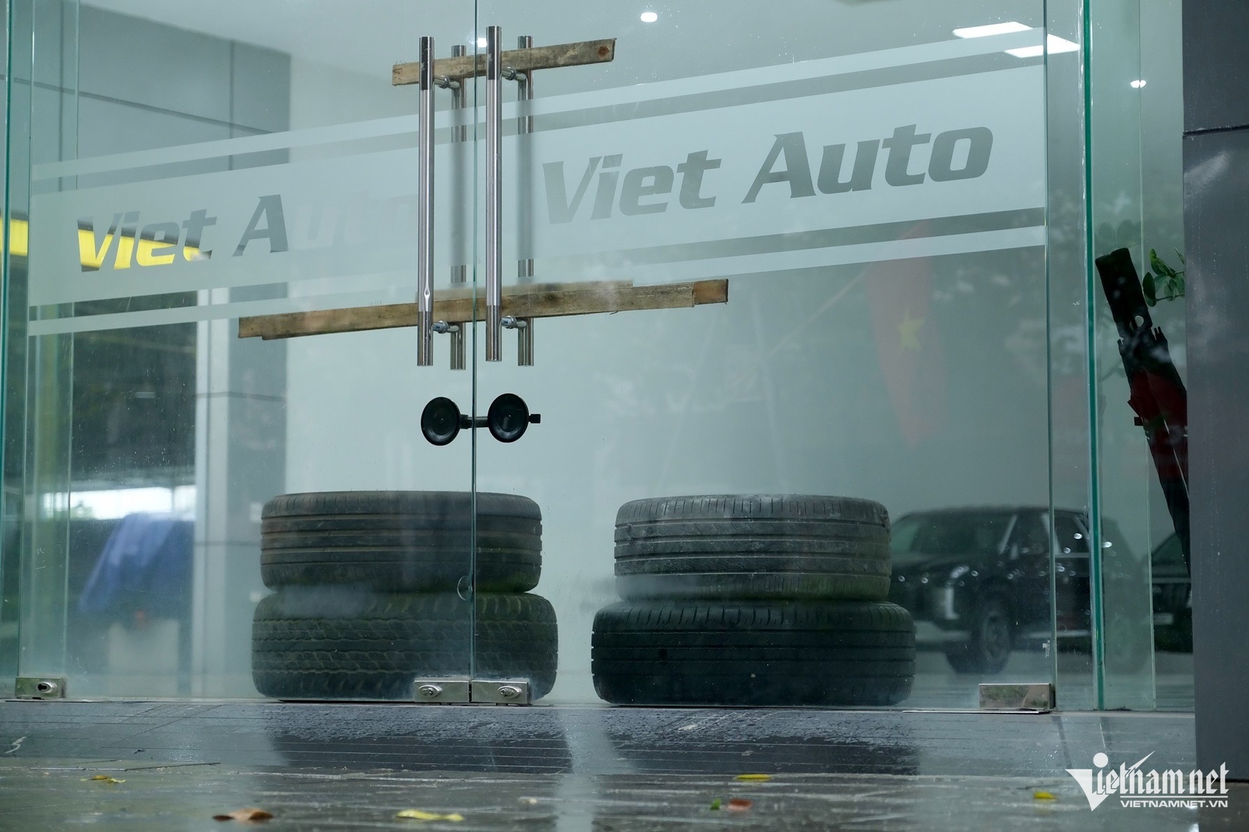 Lốp xe cũng được đem ra để chống gió bão làm vỡ kính. Ảnh: Hùng Nguyễn