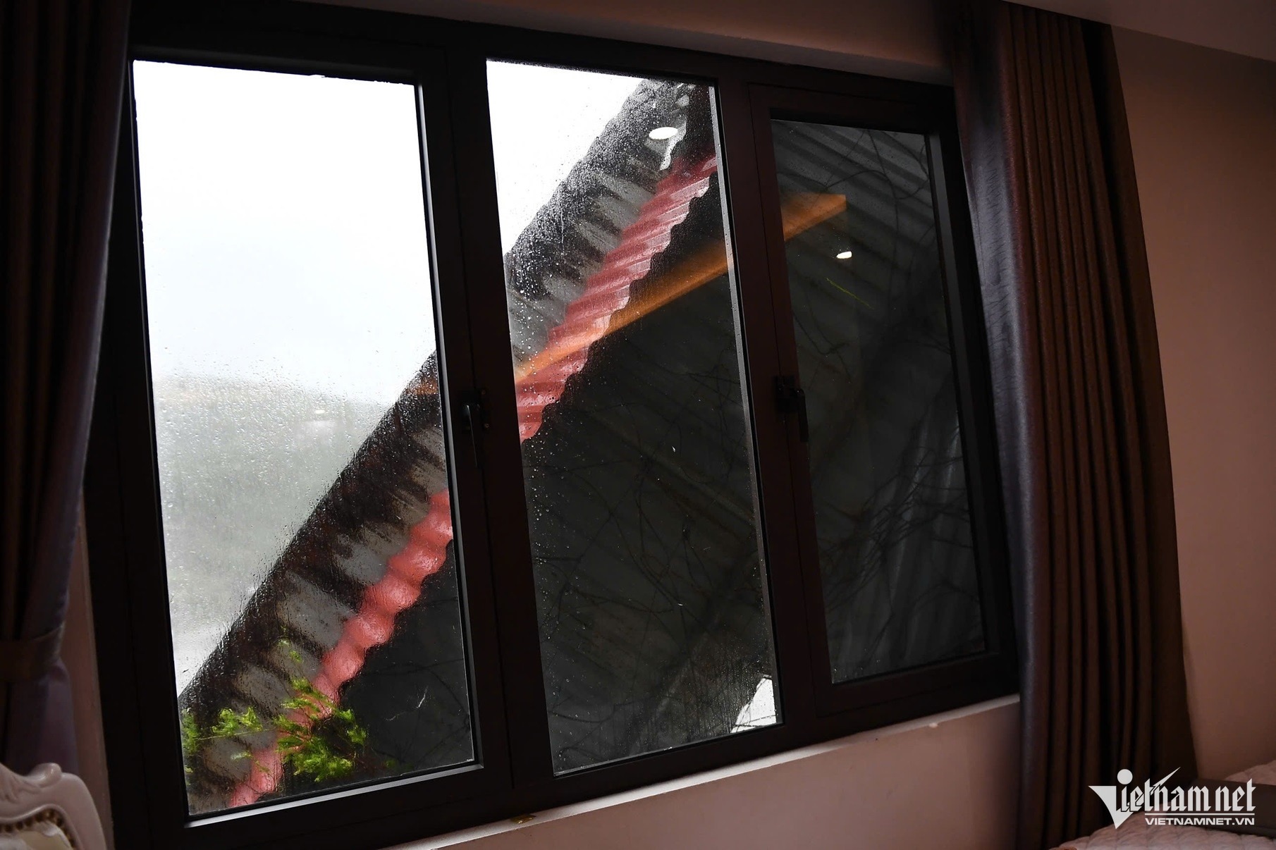 Toàn bộ phần mái tôn trên tầng 7 của một tòa nhà bị gió lật, bay thẳng xuống đường. Ảnh: Thạch Thảo