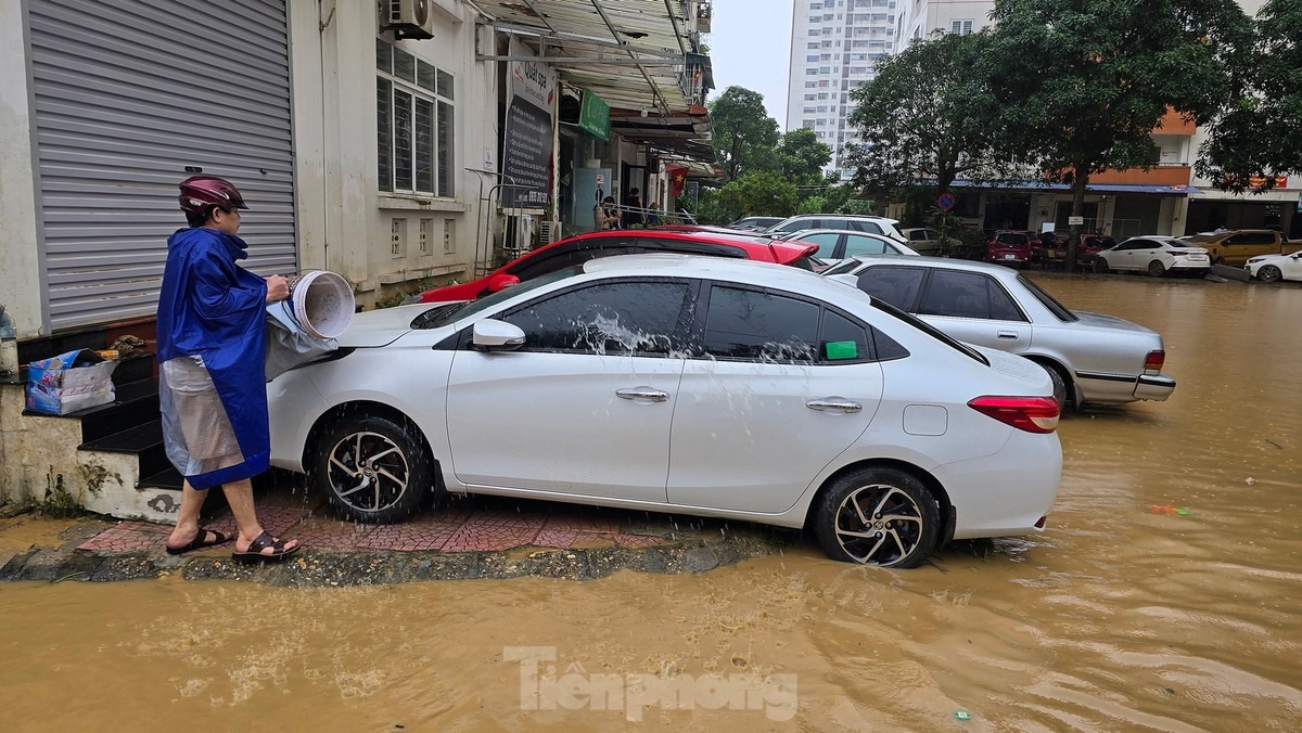 Một chủ xe tranh thủ xuống rửa vết bùn đất còn bám trên xe. Ảnh: Hoàng Mạnh Thắng.