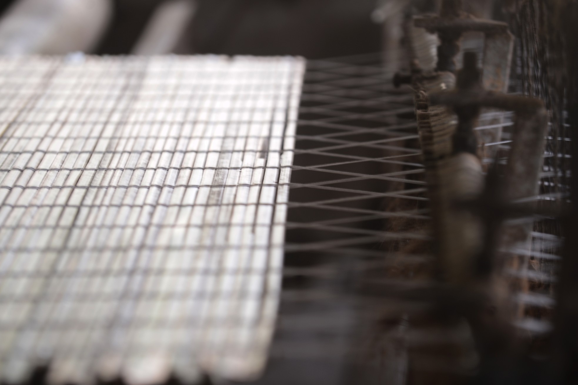 Một tấm mành cọ dần hình thành trên máy dệt, dưới bàn tay thao tác của người làm cọ Quảng Yên.