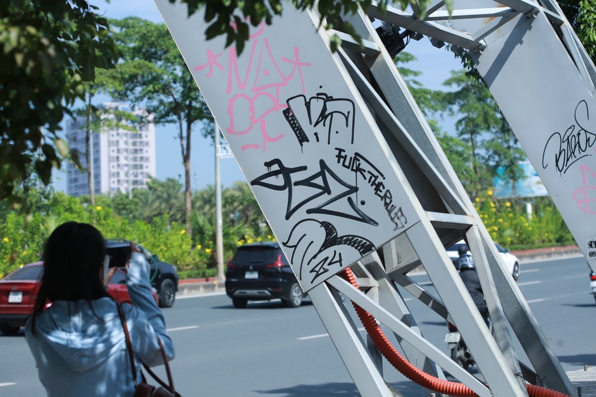 Các hình thù dị hợm được vẽ bậy đè lên nhau dưới chân cổng chào.