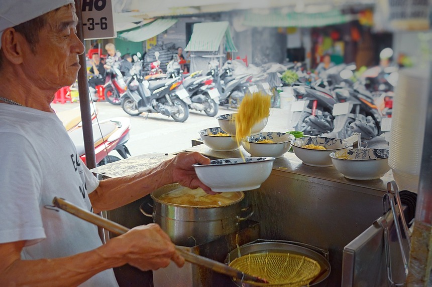 Người bán mì lâu năm thực hiện động tác tung hứng vắt mì khi trụng nước sôi
