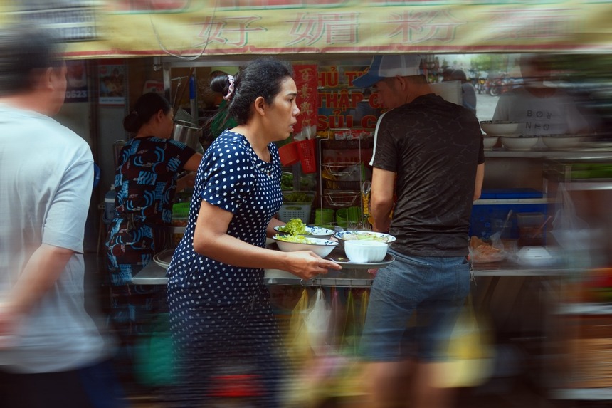 Người phục vụ của một quán hủ tiếu hoạt động không ngơi tay trong một buổi sáng đông khách