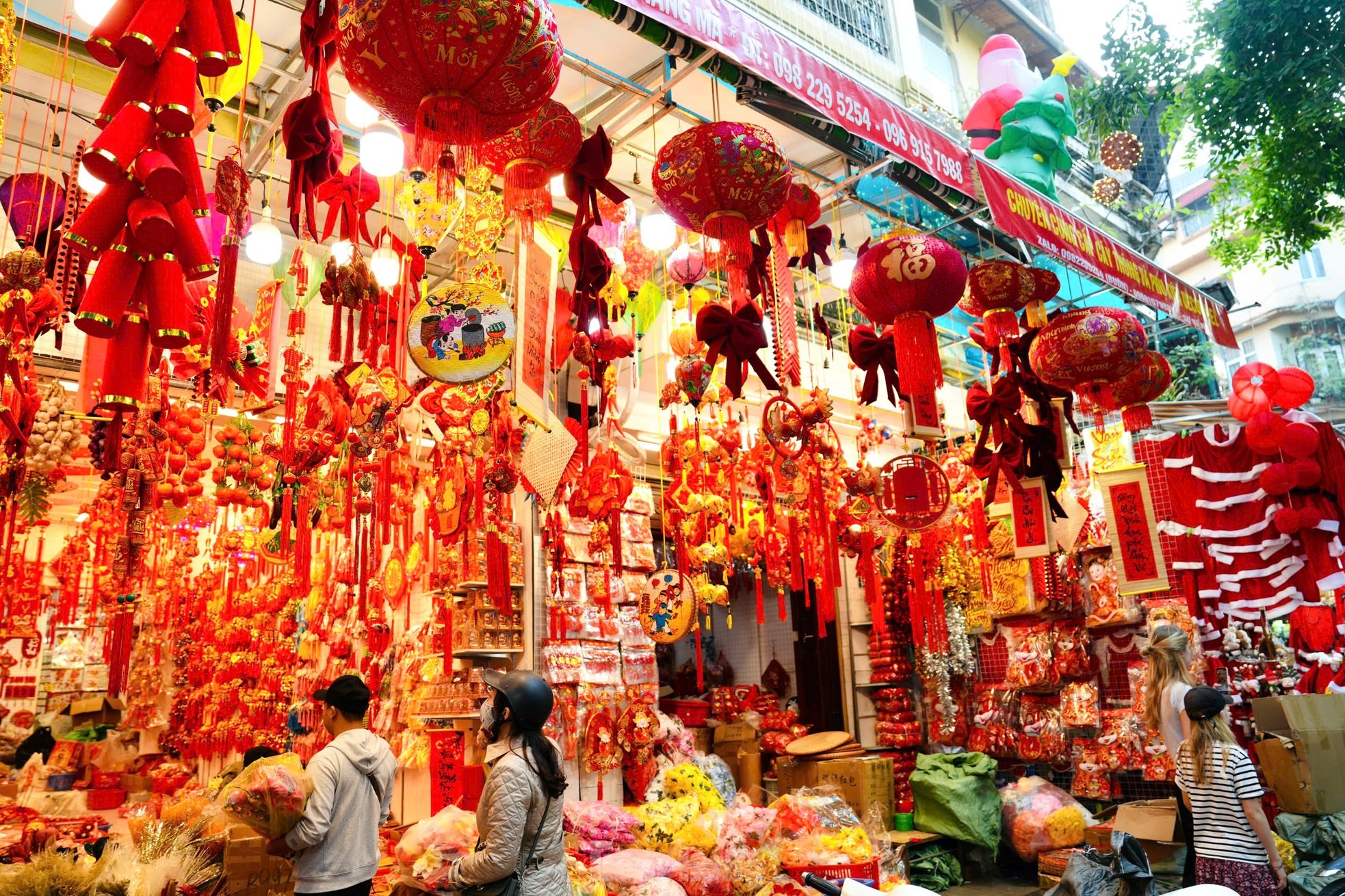 Các cửa hàng bày bán đa dạng đồ trang trí Tết như cành đào, pháo dây, bao lì xì, đèn lồng, câu đối...