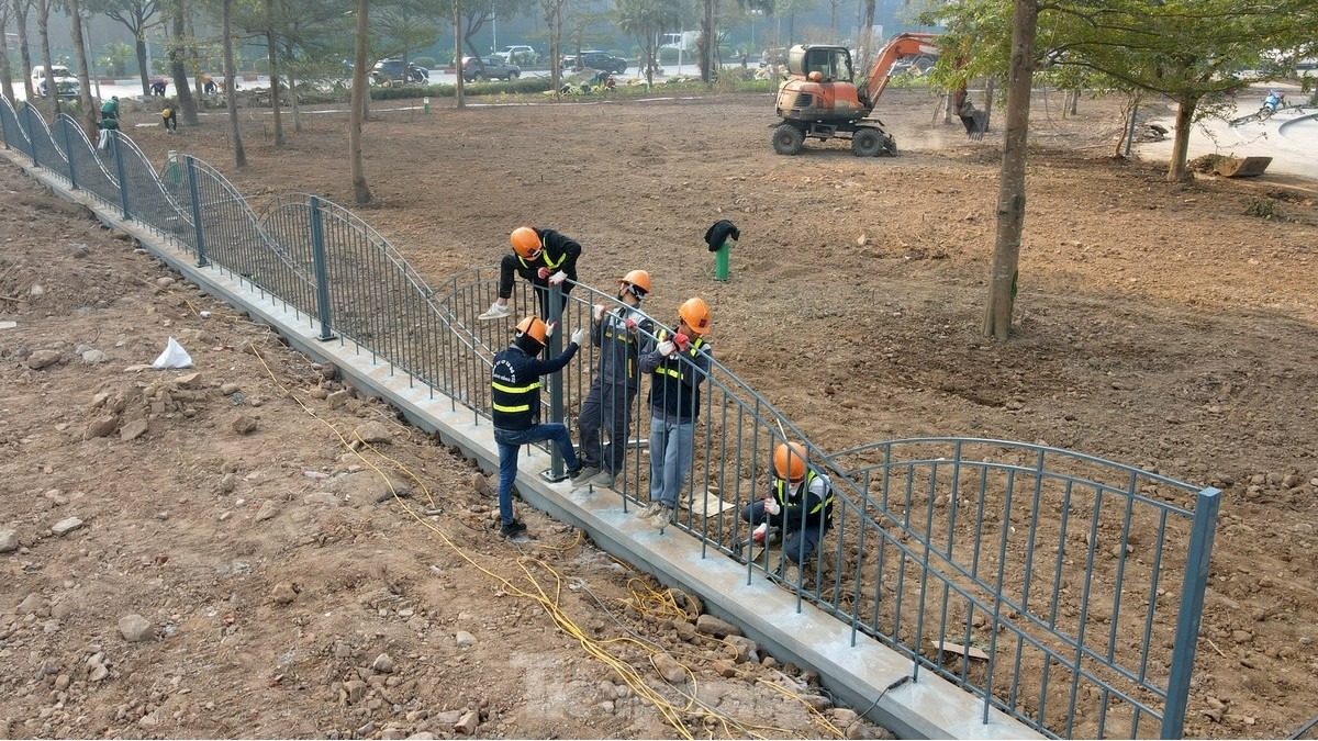 Khu vực vỉa hè được lát đá mới, vườn hoa đang được lắp đặt hàng rào.