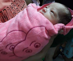 Bé trai còn nguyên dây rốn, gói trong túi treo trên xe người đi đường