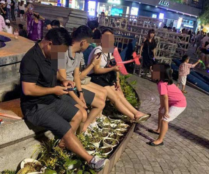 Bức xúc hình ảnh hàng chục người ngồi bên đài phun nước phố đi bộ Hồ Gươm, thản nhiên đạp chân thẳng lên hàng hoa trang trí