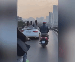 Video: Ngồi lên thành xe thả tờ rơi, nhóm cô gái bị 'ném đá' dữ dội