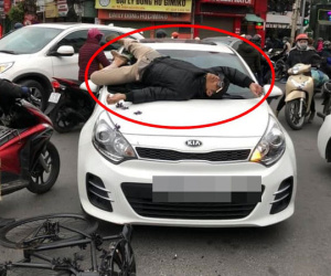 Va chạm giao thông không hòa giải được, người đàn ông leo lên nắp capo ô tô nằm