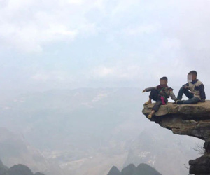 Hai bé trai ngồi trên mỏm đá cao treo leo ở Hà Giang để 'thu tiền' check-in khách du lịch