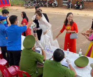 Đám cưới mùa dịch: Cô dâu chú rể cùng họ hàng 2 bên xếp hàng chờ đo thân nhiệt  trước khi vào hôn trường