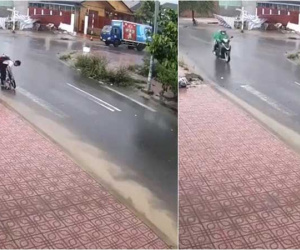 Dừng xe đạp giữa trời mưa, cậu học sinh nhỏ dùng tay thông cống thoát nước công cộng