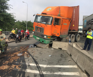 Xe container ủi dải phân cách, dầu nhớt tràn ra đường khiến nhiều người trượt ngã