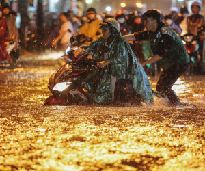 Người Sài Gòn vật lộn với đường ngập lút bánh xe, nước chảy cuồn cuộn như thác trong đêm mưa lớn