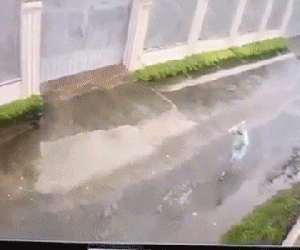 Clip: Kinh hoàng cảnh mảng tường bất ngờ đổ sập trong cơn mưa, đè lên cô gái đi bộ khiến nạn nhân nằm bất động