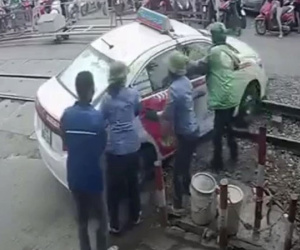 Tước bằng lái của tài xế xe taxi cố tình vượt rào chắn đường sắt