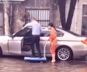 Sốc với hình ảnh người đàn ông ăn mặc lịch sự đứng trên xe đẩy để một phụ nữ đưa lên ô tô cho khỏi ướt giày, dân tình thắc mắc 'tưởng mình là hoàng đế hay sao?'