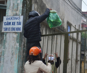 Ảnh: Người dân Đông Anh trèo cổng, mang gà, rau tiếp tế cho người thân trong khu cách ly