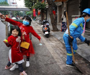 Hình ảnh 'gây sốt' MXH mùng 1 Tết: 2 bé gái mặc áo dài theo mẹ đi làm trên mọi nẻo đường