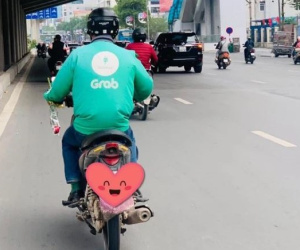 Khoảnh khắc ấm áp ngày 8/3: Người đàn ông đi xe ôm công nghệ tay cầm theo bông hồng nhỏ xinh để dành tặng người phụ nữ mình yêu thương