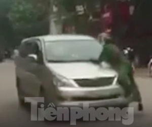 Lao ô tô vào tổ tuần tra rồi bỏ chạy, cảnh sát phải đu bám trên nắp ca pô hàng trăm mét