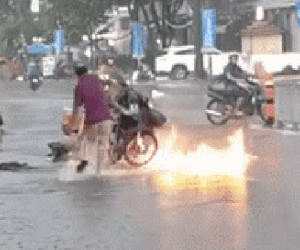Xe máy bốc cháy giữa trời mưa lớn, hành động dập lửa của ba người đàn ông gây tranh cãi