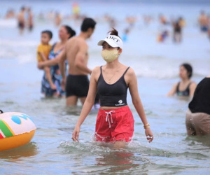 Nhiều người dân và du khách đeo khẩu trang khi tắm biển Đà Nẵng