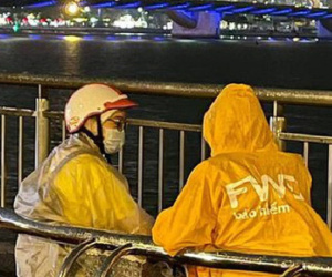 Đang ngồi hàn huyên ngắm cầu Rồng thì gặp trời mưa, đôi bạn thản nhiên làm một việc khiến ai cũng té ngửa