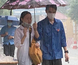Chàng trai tình nguyện che ô cho các sĩ tử tránh cơn mưa bất ngờ, danh tính khiến dân mạng 'phát sốt'