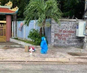 Xót xa với hình ảnh em bé mặc đồ bảo hộ một mình đứng đợi xe, dưới chân lỉnh kỉnh đồ đạc chuẩn bị đi cách ly