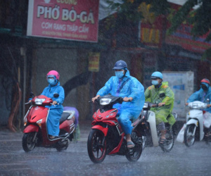 Ảnh: Người dân Hà Nội vật vã di chuyển trong cơn mưa tầm tã buổi sáng sớm