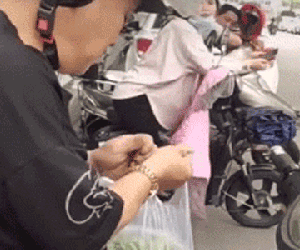 Xếp hàng chờ đón con, ông bố ngồi trên xe máy làm một việc khiến hội chị em xung quanh phải há hốc miệng: Đúng là bậc thầy của sự tranh thủ!