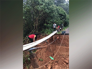 Nạn nhân lũ lụt trèo qua cây cầu gãy để gặp mẹ bị mắc kẹt