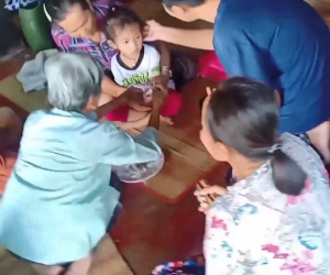 Người dân buộc chỉ vào cổ tay cho bé gái sống sót duy nhất sau vụ thảm sát tại trường mầm non Thái Lan để cầu may mắn