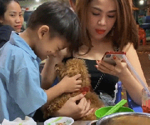 Khoảnh khắc bé trai bán hàng rong say mê âu yếm cún con và phản ứng đầy dịu dàng của vị khách nữ khiến ai nấy ấm lòng