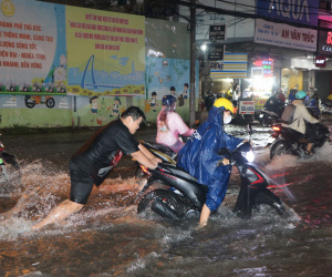 TPHCM: Nước chảy như thác sau cơn mưa lớn, người dân vất vả đẩy xe máy