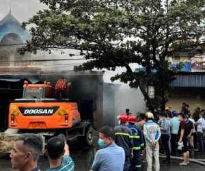 Cảnh sát dùng máy múc phá khóa dập lửa trong căn nhà bốc cháy