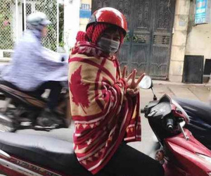 Quấn chăn chống rét khi đi xe máy, dân mạng chia phe tranh cãi